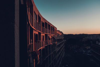 Low angle view of buildings against clear sky at sunset