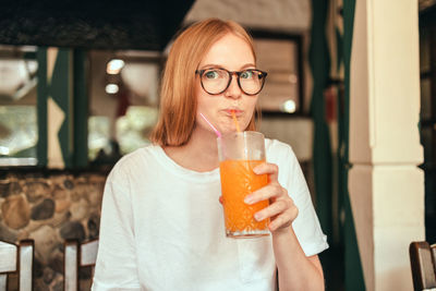 Portrait of young woman drinking glass
