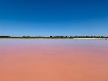 Scenic view of lake against clear blue sky