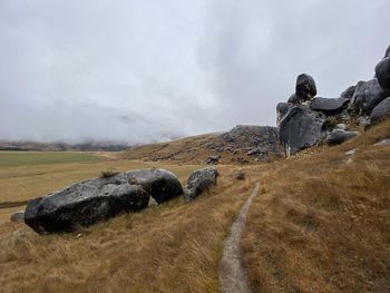 Rock formations on field against sky