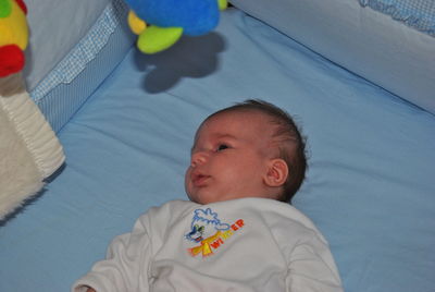 High angle view of baby lying in crib at home