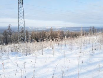 Scenic view of snow covered field against sky