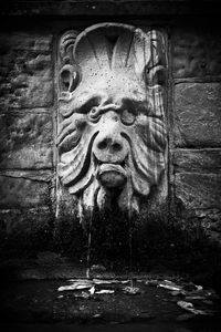 Close-up of old statue against fountain