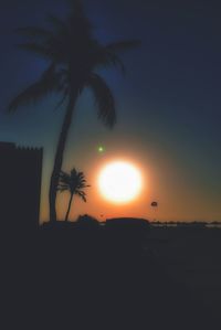 Silhouette palm trees against sky during sunset