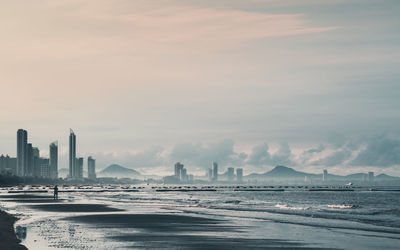 View of city by sea against sky