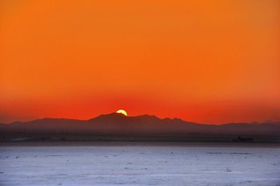 Scenic view of sea against orange sky