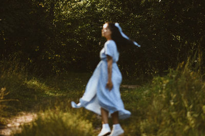 Rear view of woman standing on grassy field