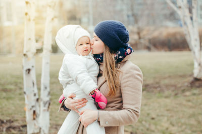 Woman wearing hat standing in park during winter