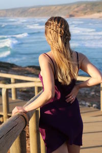 Rear view of woman standing against sea