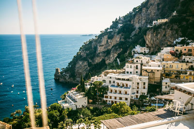 High angle view of buildings and rocky mountains by sea at positano