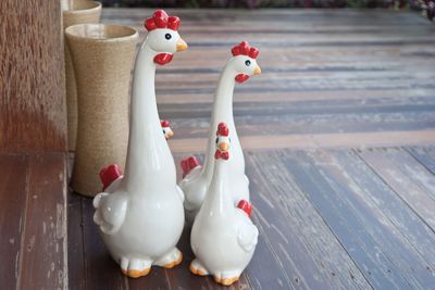 Close-up of hen figurines on hardwood floor