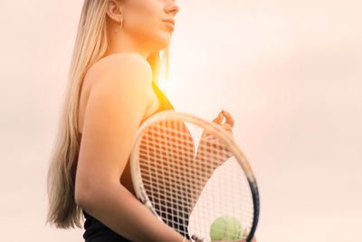 Midsection of young woman standing against white background