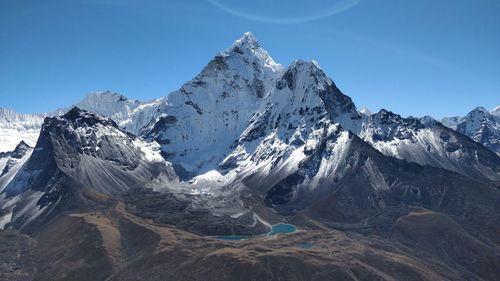 Scenic view of snowcapped mountains against clear blue sky