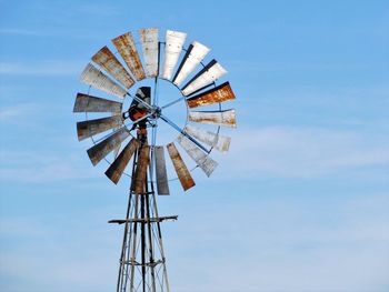 Low angle view of traditional windmill against blue sky