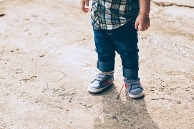 Low section of boy standing on floor