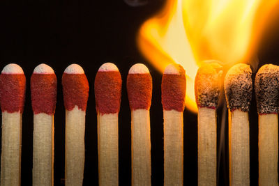 Close-up of burning matchsticks against black background