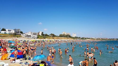 Group of people at beach against sky