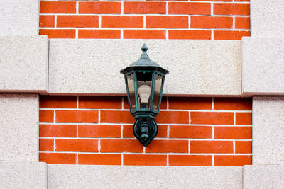 Close-up of street light against brick wall