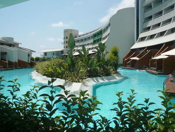 Swimming pool by buildings against sky