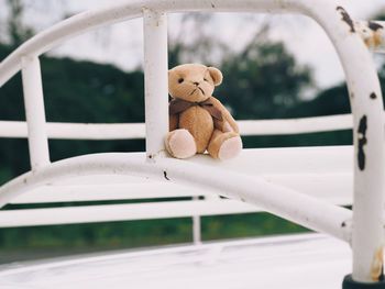 Close-up of stuffed toy on railing