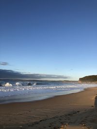 Scenic view of beach against clear blue sky