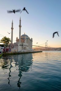 View of mosque at waterfront against sky