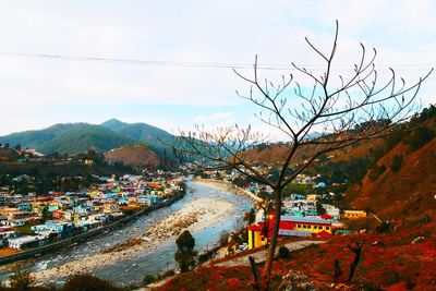 Aerial view of city buildings and mountains against sky