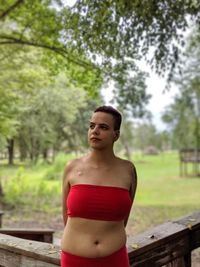 Young woman looking away while standing by railing