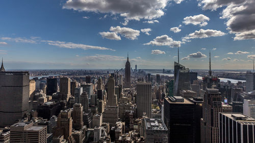 Aerial view of cityscape against cloudy sky