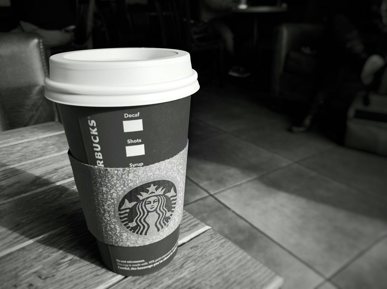 table, indoors, drink, text, focus on foreground, coffee cup, still life, food and drink, communication, refreshment, cafe, close-up, western script, high angle view, wood - material, no people, coffee - drink, day, restaurant, incidental people