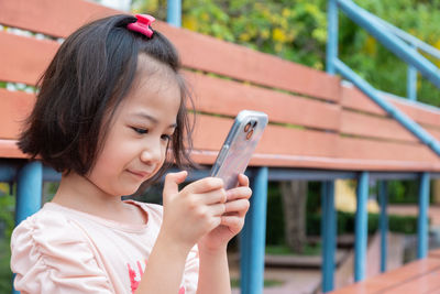 Side view of young woman using mobile phone