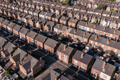 Aerial view above rooftops of back to back terraced houses on a residential estate in north england