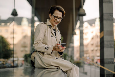 Young woman using mobile phone in city