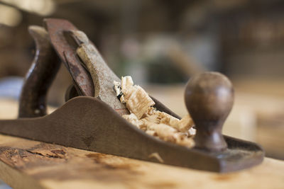 Close-up of chisel with shavings on wood