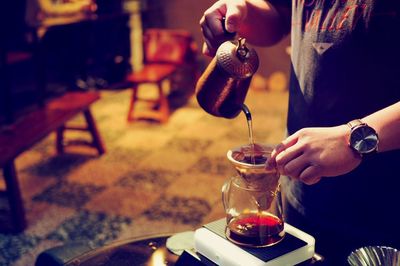 Midsection of man making coffee