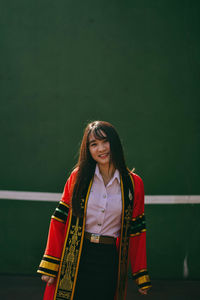 Portrait of smiling young woman standing outdoors