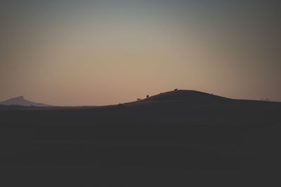 Scenic view of silhouette mountain against clear sky at sunset