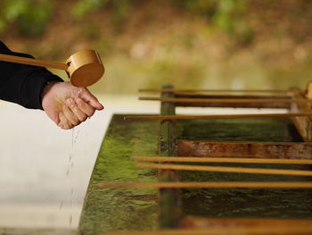 Close-up of hand holding ladle by fountain