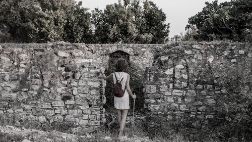 Full length of young woman standing by tree