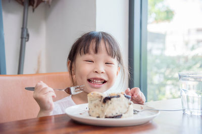 Close-up of girl eating cake at home