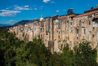 Panoramic view of old building by city against sky