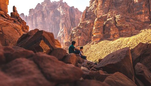 Men sitting on rock formation