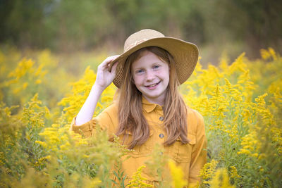 Young girl in yellow dress in a field of flowers