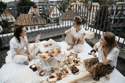 Young woman sitting on table with people in front of building