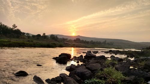 Scenic view of river at sunset