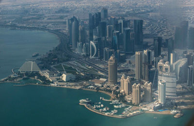 High angle view of modern buildings by sea in city