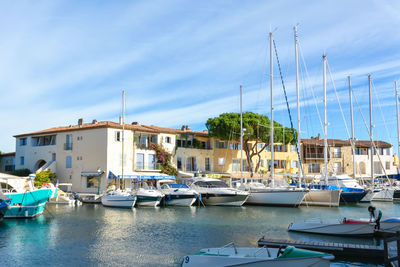 Boats moored at harbor against sky