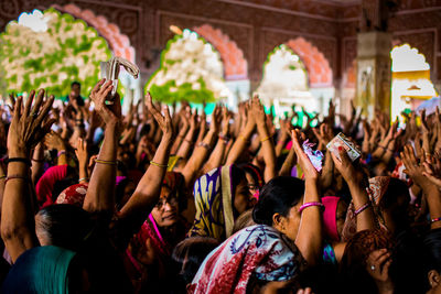 Women with arms raised at temple