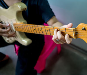 Midsection of man playing guitar