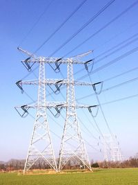 Electricity pylon on field against sky